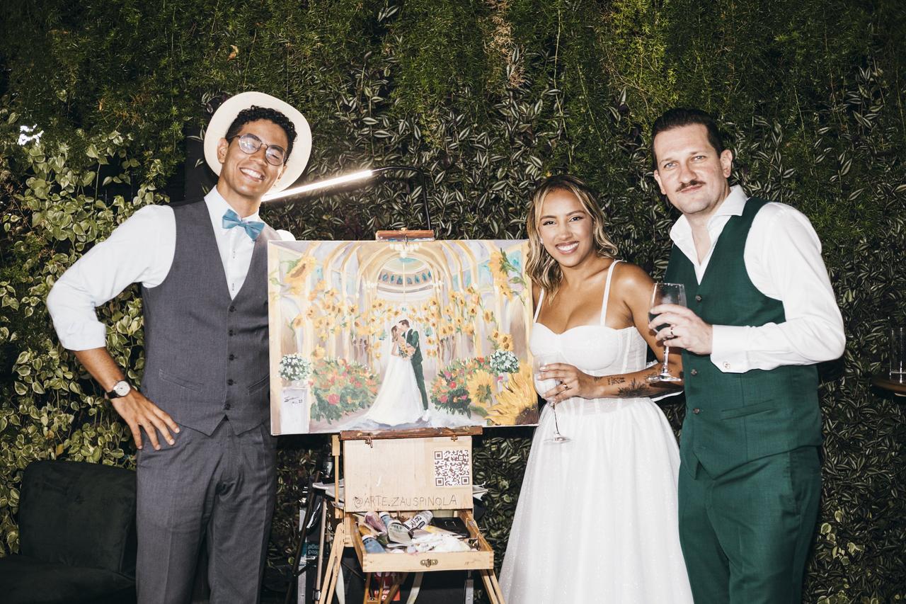 Zau Spínola e casal apreciando a obra pintada ao vivo